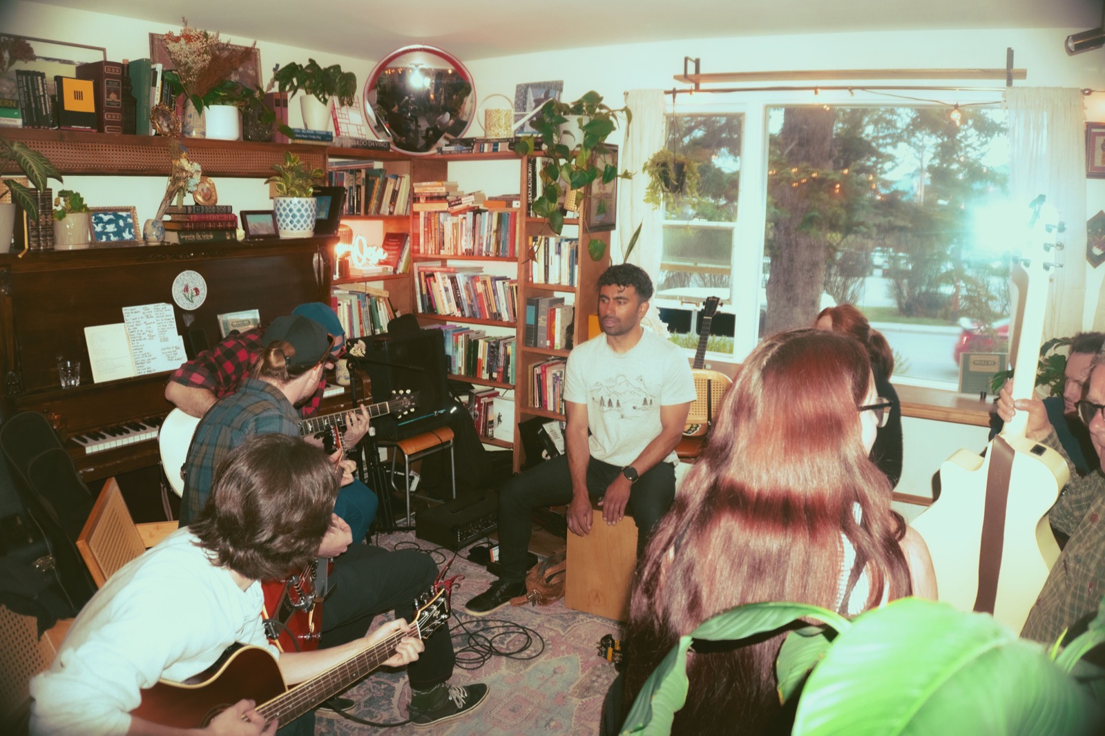 Musicians gathered around the piano during a café jam