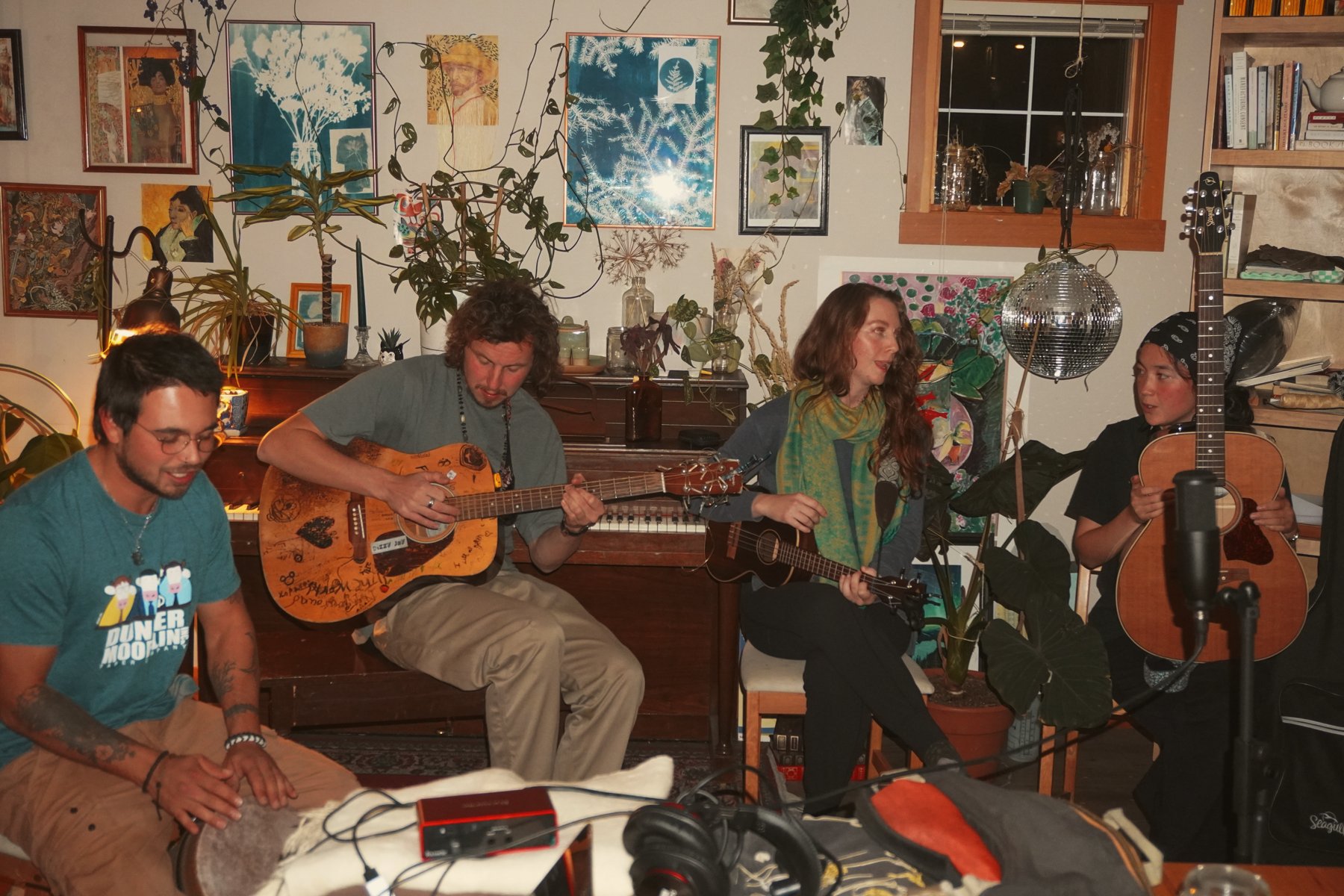 Musicians sharing songs in a room filled with art