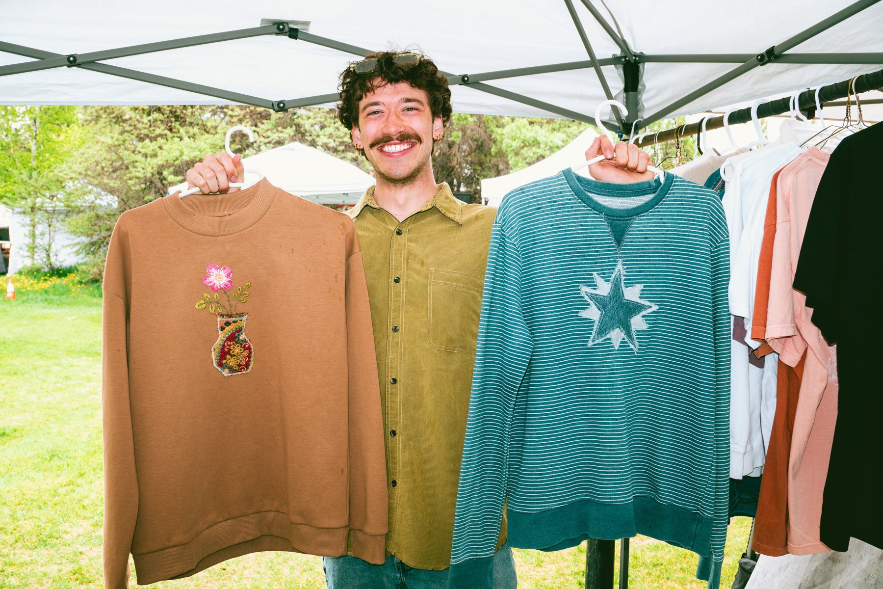 Handmade artwork and clothing displayed by a local market artist