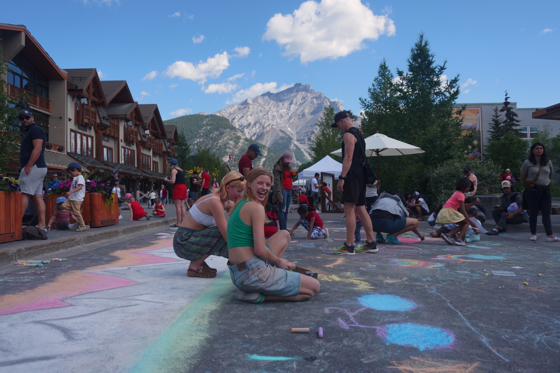 People making chalk art together on a street in Banff