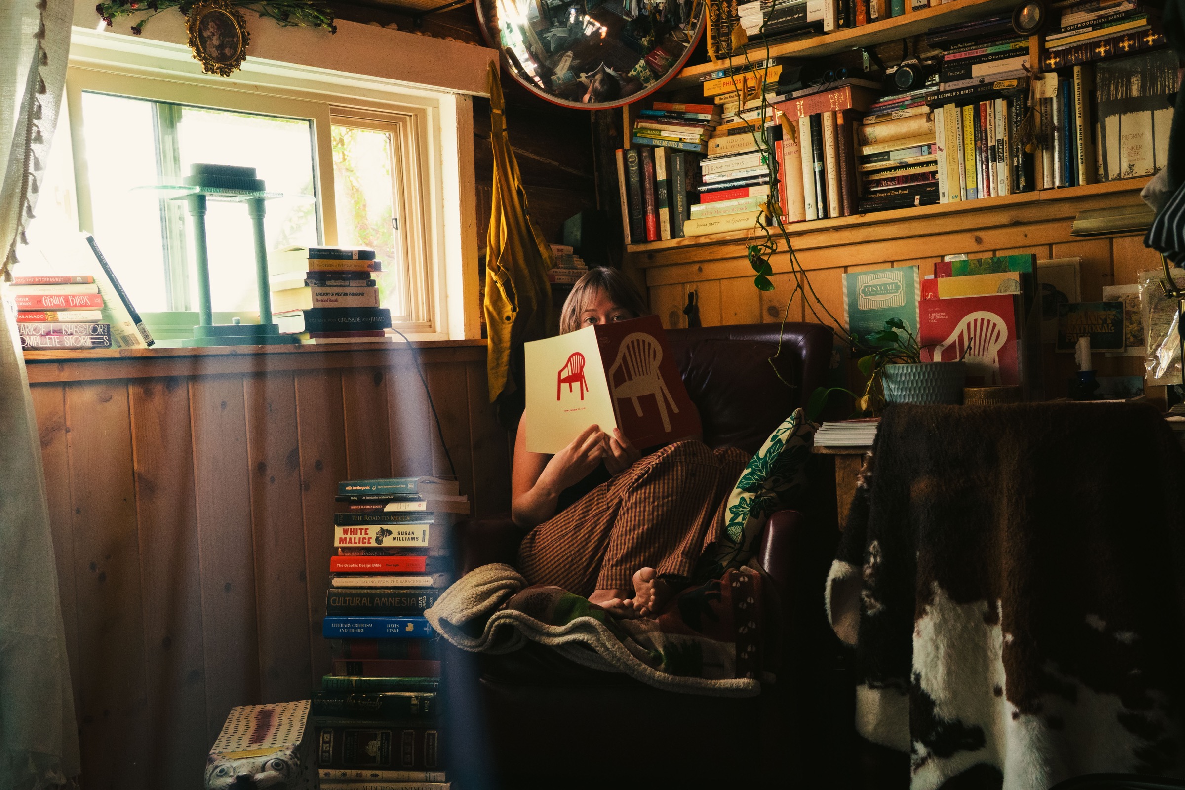 A reader enjoying the Oesa magazine in a book-filled room